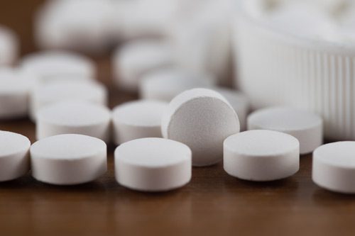 closeup of a pile of white round tablet pills - Ritalin